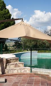 a tan umbrella sitting next to a swimming pool at Lavanda - Villa Rita in Gualdo Cattaneo