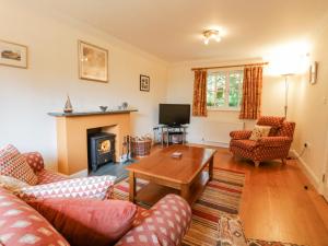 een woonkamer met banken, een tafel en een open haard bij Orchard House in Ambleside