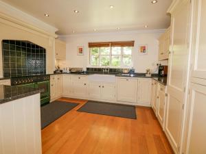 een keuken met witte kasten en een houten vloer bij Orchard House in Ambleside