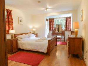 een slaapkamer met een bed met een rood tapijt bij Orchard House in Ambleside