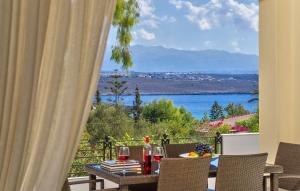 a table with wine glasses and a view of the water at Villa Plumeria Flower in Tersanas