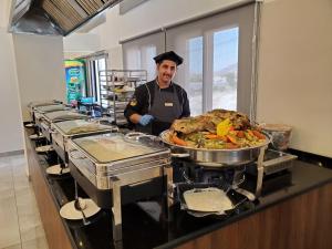 a chef standing in a kitchen preparing food at Petra Icon Hotel in Wadi Musa