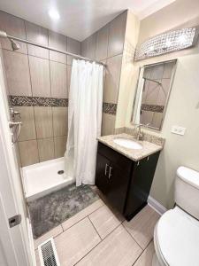 La salle de bains est pourvue d'une douche, d'un lavabo et de toilettes. dans l'établissement Beautifully Renovated House 10 mins from Downtown, à Chicago