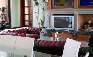 a living room with a couch and a table and a tv at Margherita - Villa Rita in Gualdo Cattaneo