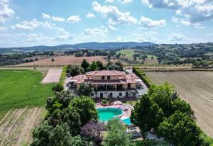 an aerial view of a house with a pool in a field at Margherita - Villa Rita in Gualdo Cattaneo