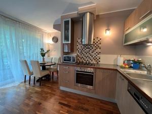 a kitchen with a sink and a table with chairs at Villa 24B in Pobierowo