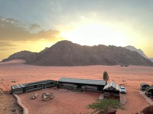 a building in the middle of a desert with a mountain at Sunset Dreams camp in Wadi Rum
