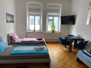 a room with two beds and a table and windows at GoyApartment für Handwerker & Business City-nah!! free Netflix! modern! in Bochum