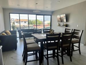 uma sala de jantar com uma mesa e cadeiras e um sofá em DEPARTAMENTOS ARTICULO 123 - departamento #1 em Tijuana