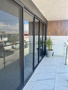 um quarto com portas de vidro e uma varanda com plantas em DEPARTAMENTOS ARTICULO 123 - departamento #1 em Tijuana