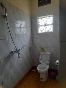 baño pequeño con aseo y ventana en Zoe Heights Guest House, en Kampala