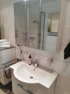a white bathroom with a sink and a shower at Appartement mit 2 Schlafzimmern-für 3 Personen -Zentral gelegen in Leverkusen Wiesdorf - Friedrich Ebert Platz 5a , 4te Etage mit Aufzug- 2 Balkone - in Leverkusen