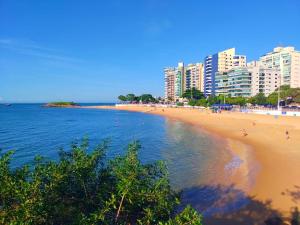 a beach with buildings and people on the sand and water at AP Top na Praia da Costa in Vila Velha