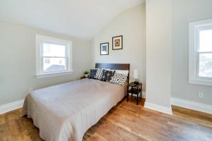 a bedroom with a large bed and two windows at Bright Pittsburgh Apt, Walk to Grandview Ave! in Pittsburgh