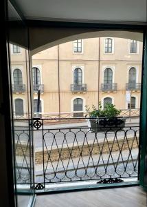 Maiolica Apartment في كالتانيسيتا: اطلالة نافذة على مبنى يوجد به نبات على شرفة