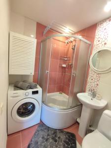 a bathroom with a shower and a washing machine at Sunset 26 in Liepāja