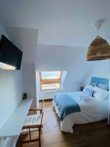 1 dormitorio con 1 cama, TV y ventana en EL TRASTERO DE PALMERO, en A Coruña