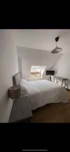 a bedroom with a large white bed and a window at EL TRASTERO DE PALMERO in A Coruña