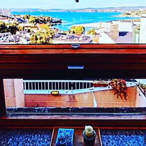 a window with a view of a city and the ocean at EL TRASTERO DE PALMERO in A Coruña