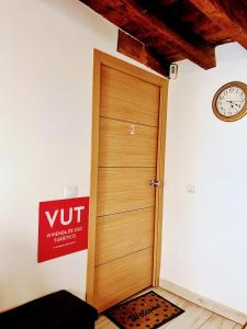 una puerta de madera en una habitación con un reloj en la pared en Felices Los Cuatro, en Toledo