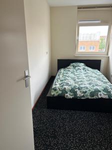 een slaapkamer met een bed en een raam bij Chico in Almere