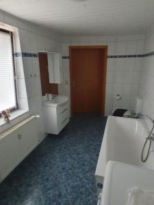 a bathroom with a tub and a sink and a mirror at Suite Toni in Bernburg