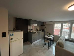a kitchen with a refrigerator and a table in it at Cozy Studio in ALexandroupolis in Alexandroupoli