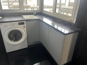 eine Waschküche mit einer Waschmaschine und einem Fenster in der Unterkunft Home of Neptune in Póvoa de Varzim