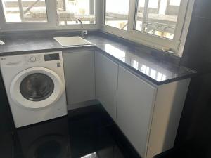 a laundry room with a washing machine and a window at Home of Neptune in Póvoa de Varzim