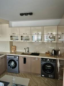 cocina con fregadero y lavadora en Ultra Lux Apartment Free Underground Parking en Pazardzhik