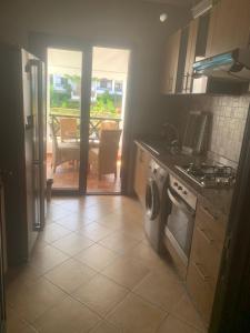 a kitchen with a stove and a dishwasher and a table at Appartement - lilac's garden cabo negro in Tetouan