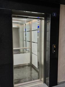 a glass elevator door in a building at Ultra Lux Apartment Free Underground Secure Parking in Pazardzhik
