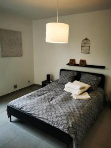 Un dormitorio con una cama con almohadas. en Villa spacieuse et stylée à 50m de la plage, en Carnon-Plage