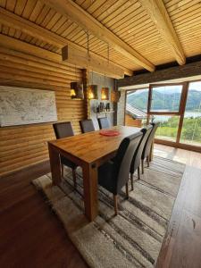 una sala da pranzo con tavolo e sedie in legno di Tara Land Lake a Zaovine