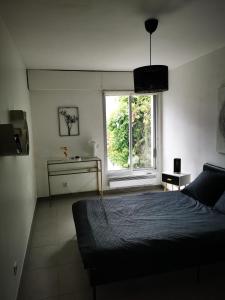 1 dormitorio con cama y ventana en Villa spacieuse et stylée à 50m de la plage, en Carnon-Plage