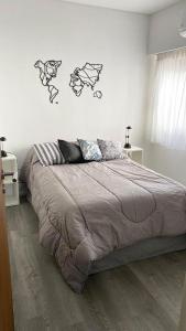 1 dormitorio con 1 cama grande con dibujos en la pared en Rosales.RM - Depto completo 2 ambientes con patio. en Ramos Mejía