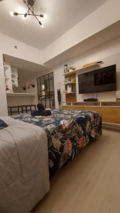 um quarto com uma cama e uma televisão de ecrã plano em SDC lovely place azure north em San Fernando