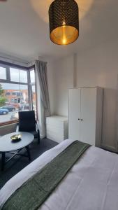 a bedroom with a bed and a table and a chair at Double Room With Kitchen Facilities in Nottingham