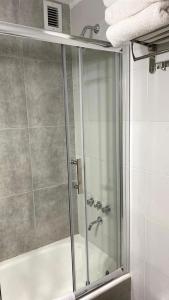 a shower with a glass door in a bathroom at Rosales.RM - Depto completo 2 ambientes con patio. in Ramos Mejía