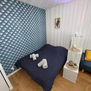 a bedroom with a bed with towels on it at Le Studio Zen "parking gratuit" in Cherbourg en Cotentin