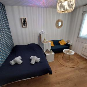 a bedroom with a blue bed with towels on it at Le Studio Zen "parking gratuit" in Cherbourg en Cotentin
