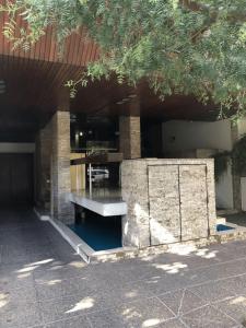 un bâtiment avec un banc dans une cour dans l'établissement Rosales.RM - Depto completo 2 ambientes con patio., à Ramos Mejía