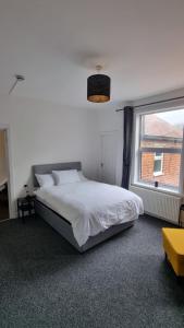 a bedroom with a white bed and a window at En Suite room with kitchen facilities in Nottingham