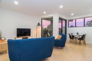 a living room with a blue couch and a table at Canopy at 44 Ovingham in Bowden