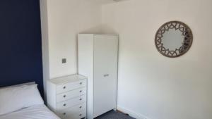 Schlafzimmer mit einem Bett, einer Kommode und einem Spiegel in der Unterkunft En Suite room with kitchen facilities in Nottingham