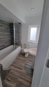 uma casa de banho com uma banheira, um WC e um lavatório. em En Suite room with kitchen facilities em Nottingham
