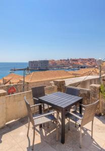 a table and chairs on a balcony with a view of the ocean at Tik tak Dubrovnik 2 in Dubrovnik