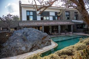 a house with a large rock next to a swimming pool at Es Cloper in Cadaqués