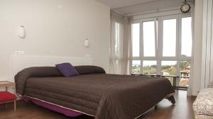 a bedroom with a bed and a large window at EL COLLADO, Ruiloba in Sierra