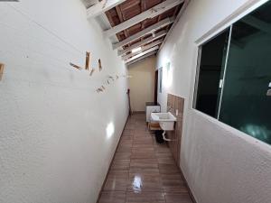 a hallway of a bathroom with a sink and a toilet at Excelente casa na praia em Matinhos PR. 600 metros da praia. in Matinhos
